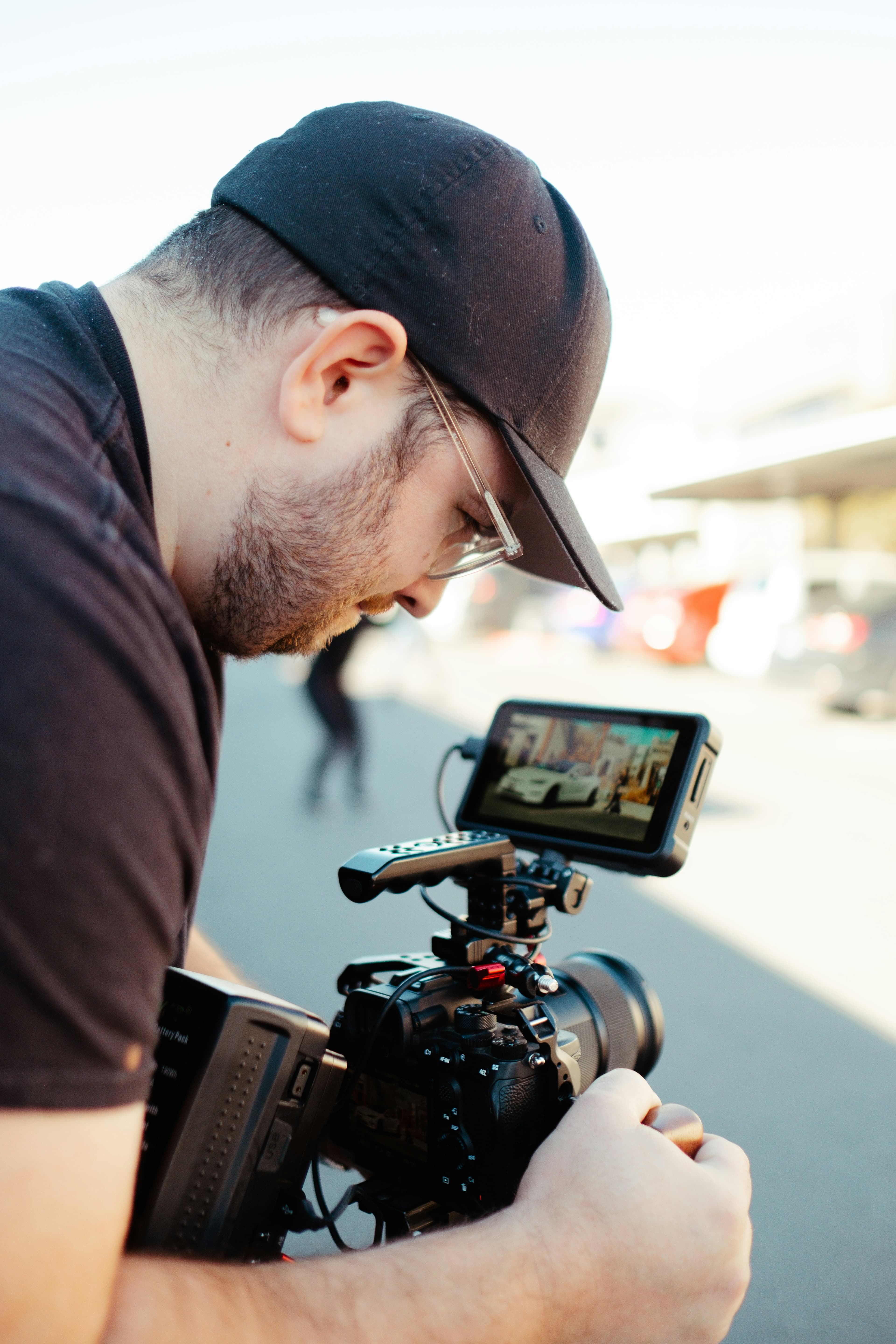 Filmare som ställer in en kamera med extern monitor ute på gatan